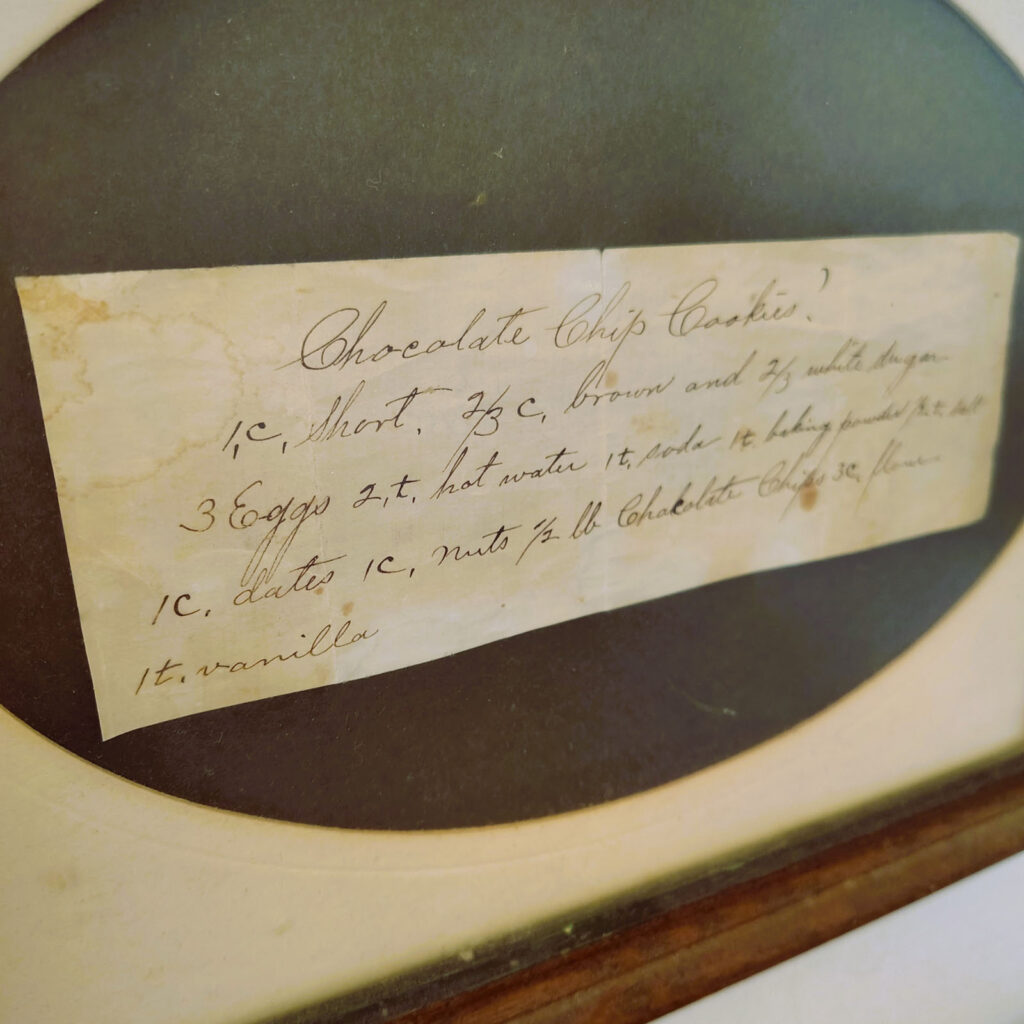 a very old recipe for chocolate chip cookies written in elegant script in an oval frame